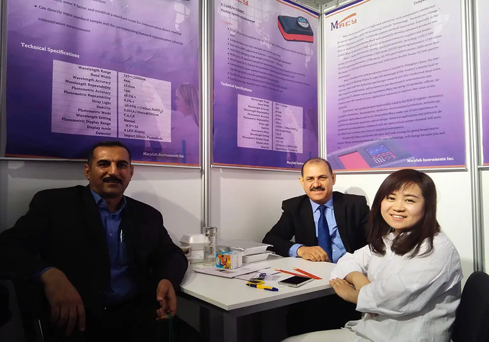 MACYLAB team members and international partners discussing spectrophotometer solutions at a scientific exhibition.