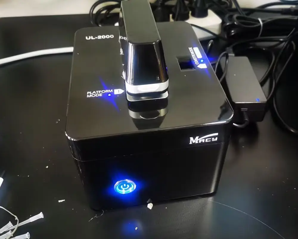 The MACY UL-2000 Micro-Volume UV-VIS Spectrophotometer in a real laboratory setting, featuring active blue LED indicators for Platform Mode and Cuvette Mode operation.